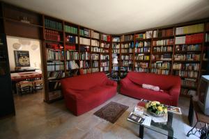 a living room with a red couch and book shelves at B&B Il Nido Di Alice in Moresco