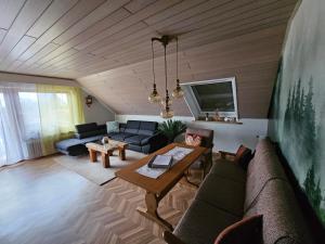 un soggiorno con divano e tavolo di Chickenhill Blackforest, Ferienwohnung Großhans a Bad Wildbad