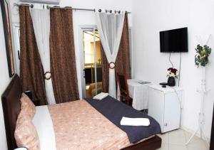 a bedroom with a bed and a television in it at Résidence Doux in Dakar
