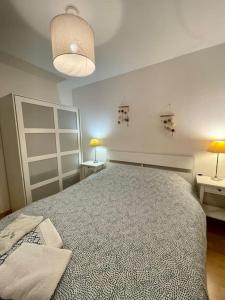 een slaapkamer met een groot bed en 2 tafels bij Joli appartement avec parking et balcon in Touques