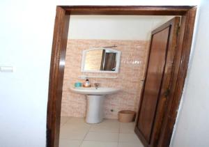 a bathroom with a sink and a mirror at Résidence Doux in Dakar