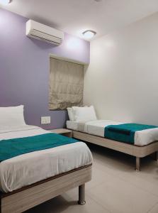 - une chambre avec 2 lits et une fenêtre dans l'établissement Apollo Guest House, à Mumbai