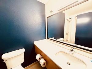 a bathroom with a white toilet and a large mirror at Spark by Hilton Modesto in Modesto