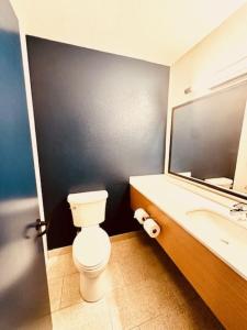 a bathroom with a toilet and a sink and a mirror at Spark by Hilton Modesto in Modesto