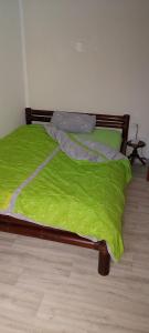 Una cama con una manta verde encima. en Zu Hause auf Zeit bei Marion, en Bobbau