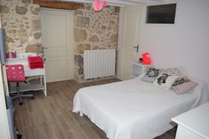 - une chambre avec un lit blanc et un bureau dans l'établissement Lavardac - Maison de Village Gascogne Landes, à Lavardac