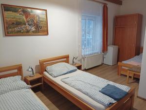 um quarto com duas camas e uma pintura na parede em Hostinec Peterka em Šumperk