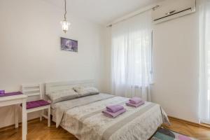1 dormitorio con 2 camas, escritorio y ventana en Studio apartment Duda, en Karaburma