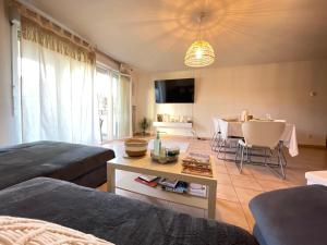 uma sala de estar com uma cama e uma mesa e uma cozinha em Résidence aux portes de Genève em Annemasse