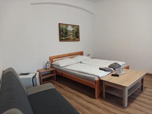 een slaapkamer met een bed, een tafel en een bank bij Hostinec Peterka in Šumperk