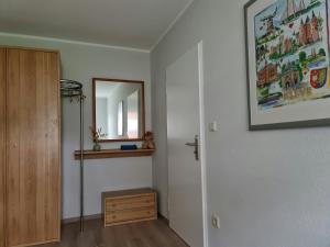 a hallway with a mirror and a dresser in a room at Ferienwohnung "Erika" Rees am Niederrhein in Rees