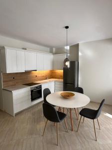 a kitchen with a table and chairs and a refrigerator at Olea Luxury Apartment in Pythagoreio