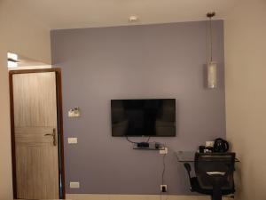 a room with a flat screen tv on a wall at Apollo Guest House - Colaba Causeway in Mumbai