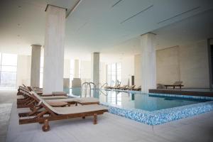 貝爾格勒的住宿－Luxury Appartment Belgrade Waterfront，一个带躺椅的游泳池和一个游泳池