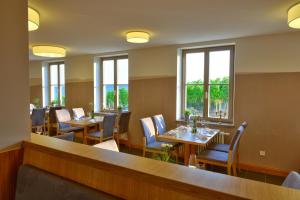 un restaurante con mesas, sillas y ventanas en Vogelsburg, en Volkach