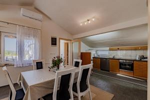 a kitchen and dining room with a table and chairs at Apartment Kesten in Janjina