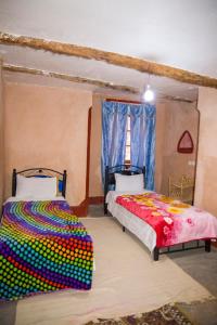 廷吉爾的住宿－Kasbah Omari，一间卧室设有两张床和窗户。