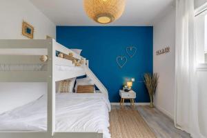 - une chambre avec un mur bleu et des lits superposés dans l'établissement Clair Jeanne - Charmante maison neuve, à Notre-Dame-de-Monts