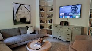 ein Wohnzimmer mit einem Sofa und einem TV in der Unterkunft Bold Stump Cottage in Lakeside