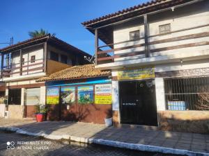 un edificio con letreros en el costado en Búzios – Geribá – Suítes - Aluguel Econômico, en Búzios