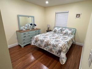 a bedroom with a bed and a dresser and a mirror at Nice and Comfortable... in Rotunda-West