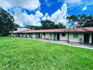 a building with a grass field in front of it at Hotel Fazenda Tordesilhas in Cocalzinho de Goias