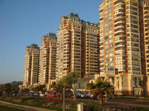 un gran edificio con palmeras delante en Primera línea Coraceros, minimo reserva 3 noches, en Viña del Mar