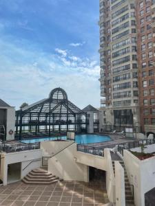 - une piscine dans un bâtiment avec un grand bâtiment dans l'établissement Primera línea Coraceros, minimo reserva 3 noches, à Viña del Mar