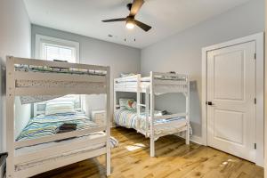 two bunk beds in a room with a ceiling fan at Oak Island Fall Getaway Coastal Home and Deck in Oak Island