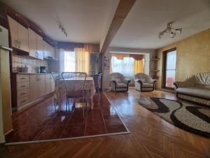 a kitchen and living room with a table and chairs at Nice & Relaxing Central Apartment in Baia Mare