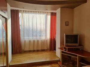 a living room with a television and a large window at Nice & Relaxing Central Apartment in Baia Mare