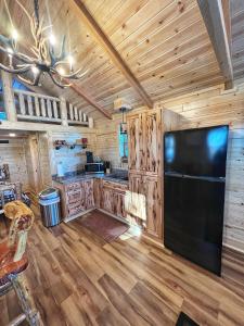 eine Küche mit einem großen schwarzen Kühlschrank in einer Hütte in der Unterkunft The Lodge at Devils Tower in Devils Tower