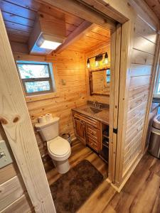 a bathroom with a toilet and a sink in a log cabin at The Lodge at Devils Tower in Devils Tower +92 photos