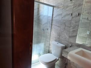 a bathroom with a toilet and a shower and a sink at ELL PALACE HOTEL in Itaberaí