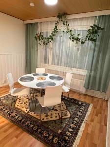 une salle à manger avec une table blanche et des chaises blanches dans l'établissement Comfortable apartment near Helsinki airport, à Vantaa