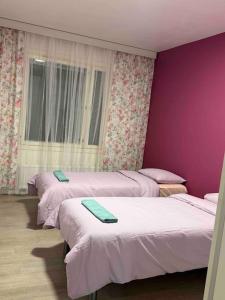 3 camas en una habitación con paredes moradas en Comfortable apartment near Helsinki airport, en Vantaa