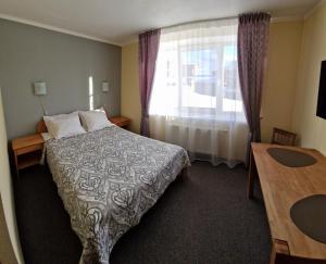 una camera d'albergo con letto e finestra di Hotel Linda - Helvita a Liepāja