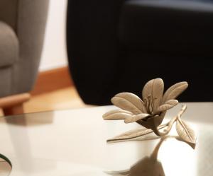 una pequeña flor de madera sentada en una mesa en Apartamento Gutierrez 02, en Belo Horizonte