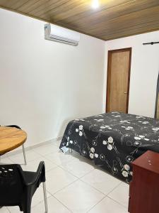 um quarto com uma cama, uma mesa e uma cadeira em Chalé 3301 em Luís Correia