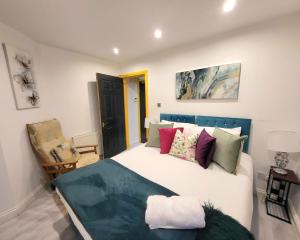 a bedroom with a large white bed with colorful pillows at Adelphi Suites By Sensational Stay Short Lets & Serviced Accommodation Aberdeen City With Free Wi-fi in Aberdeen