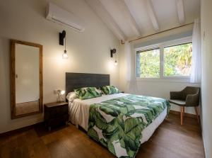 a bedroom with a bed and a mirror and a window at Apartamentos Garden Rock in Santillana del Mar