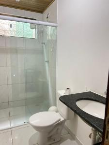 uma casa de banho com um chuveiro, um WC e um lavatório. em Chalé 3301 em Luís Correia