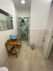 ein Badezimmer mit einem blauen Waschbecken auf einem Holztisch in der Unterkunft La Casa nel Vicolo Camera 3 in Casale Monferrato