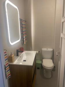 a bathroom with a toilet and a sink and a mirror at Fabrica Apart in Porto