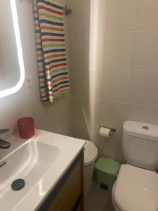 La salle de bains est pourvue d'un lavabo blanc et de toilettes. dans l'établissement Fabrica Apart, à Porto