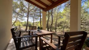 - une table en bois et 2 chaises sur une terrasse couverte dans l'établissement Apartaments ES POU, à San Ferran de Ses Roques