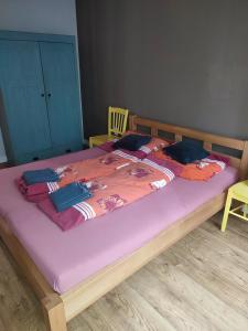 a bedroom with a large bed with a purple comforter at Bulvár apartmán in Žilina