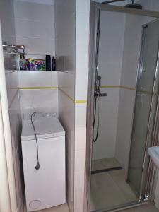 een badkamer met een douche, een wasmachine en een droger bij Bulvár apartmán in Žilina