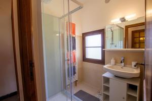 uma casa de banho com uma cabina de duche em vidro e um lavatório. em Nouzet gites et lits em Eyzerac
