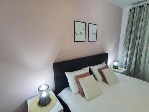 una camera da letto con letto con testiera e cuscini neri di ONE Apartment a Braşov
